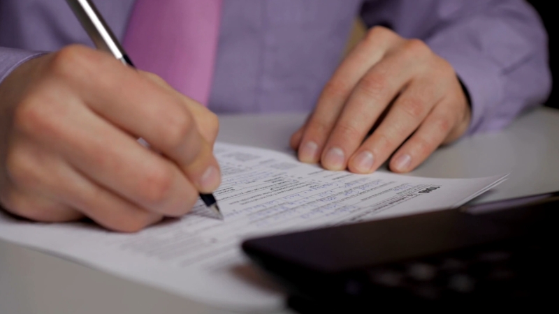 Person filling out tax correction forms after receiving a notice from the CRA