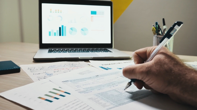 Person reviewing financial documents on a desk while checking non-reportable income in Canada