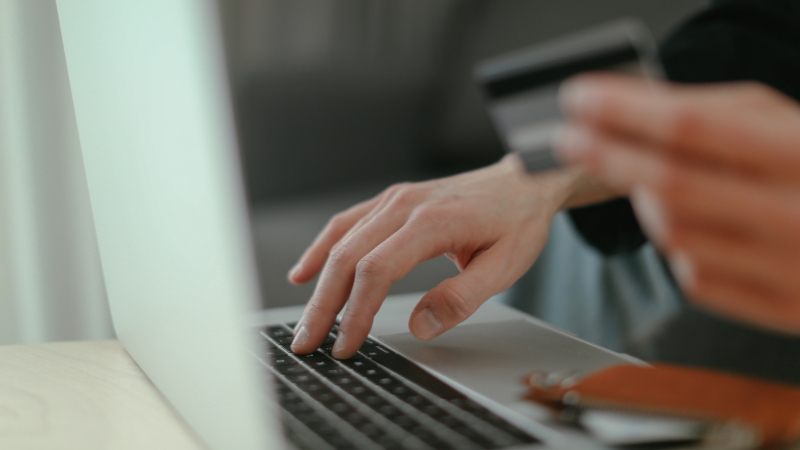 Person using a credit card online, showing small spending on entertainment in Toronto