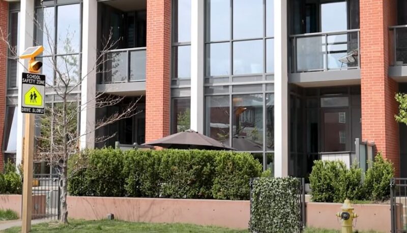 A street sign stands in front of a building, indicating the location and providing directional information