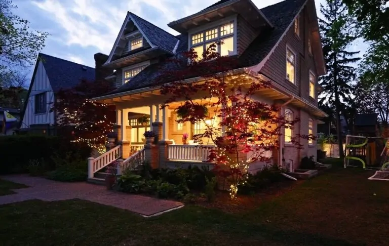 A cozy home featuring a welcoming porch adorned with lights illuminating the front