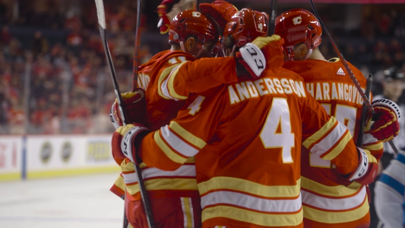 Calgary Flames players celebrate on the ice after scoring a goal