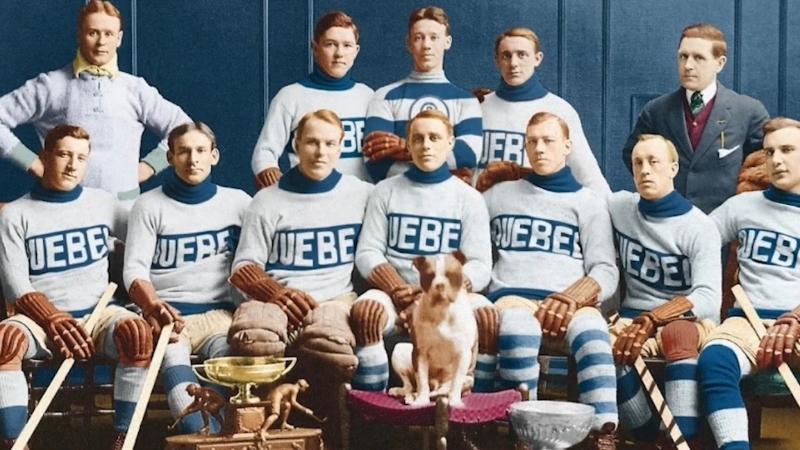 Quebec Bulldogs team posing in vintage uniforms with “QUEBEC” across their chests, surrounded by early hockey trophies