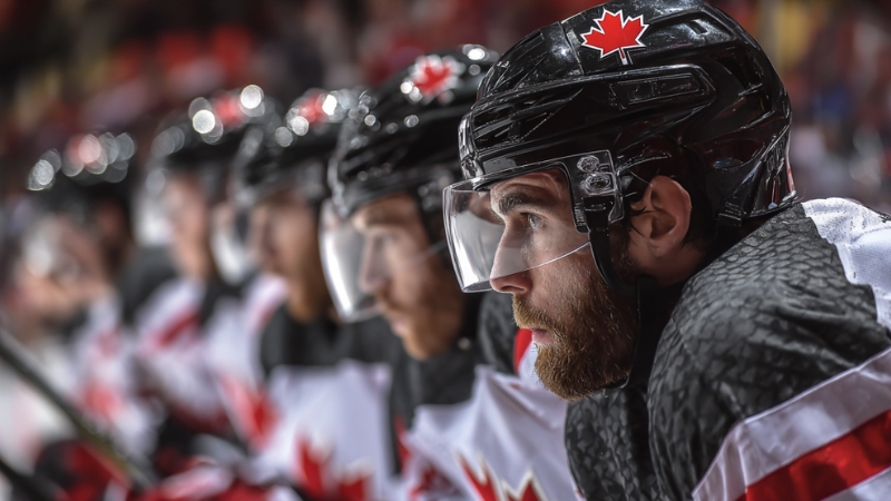 Canadian players wait on the bench with focused looks during a tense game