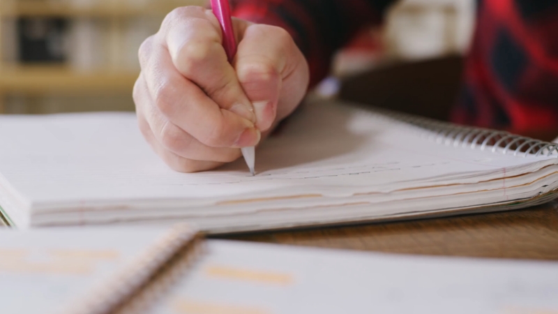 A student writes exam answers as Ontario introduces new curriculum and testing rules